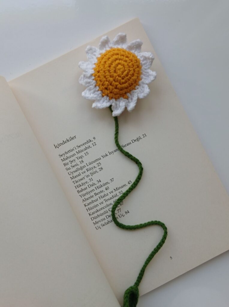 handmade crochet daisy bookmark on open book