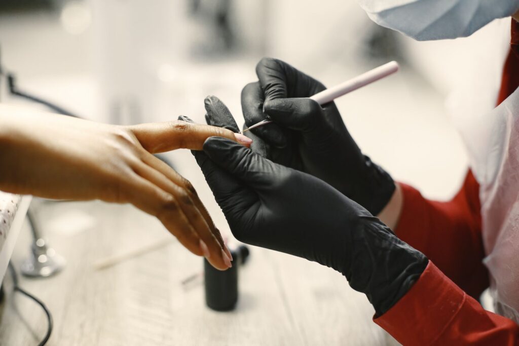 a manicurist cleaning a woman s fingernails