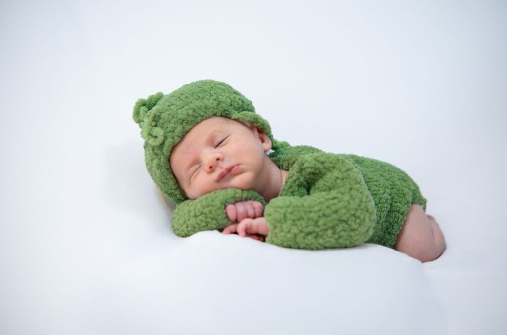 Adorable newborn in a cozy green knit outfit