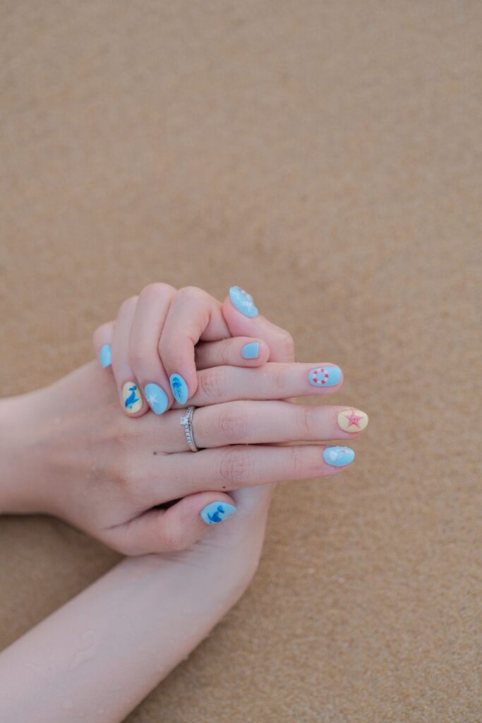 Closeup of colorful nail art on sand background