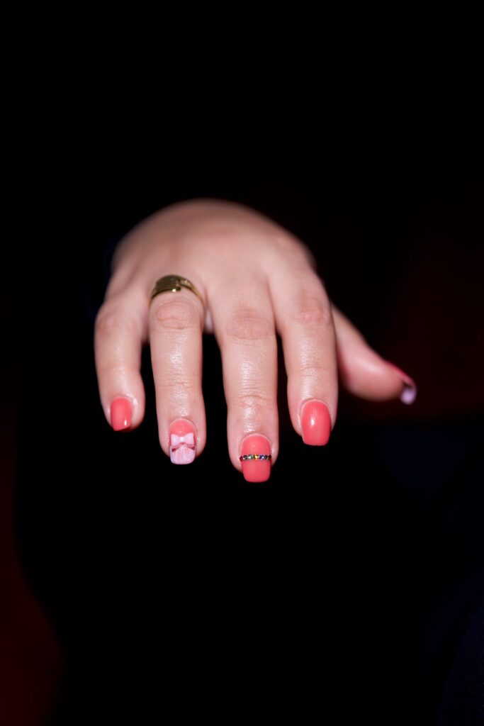 Elegant hand with pink nail art and gold ring