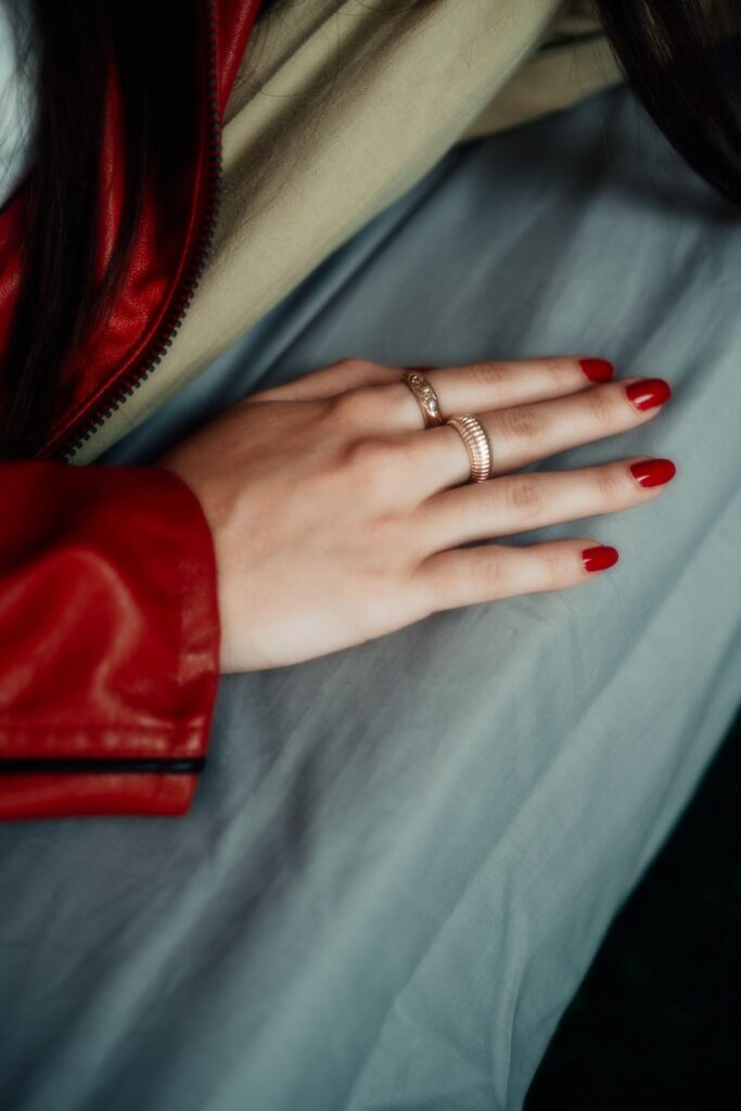 Elegant hand with red manicure and rings