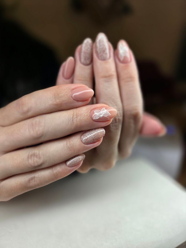 Elegant nude and glitter manicure close up