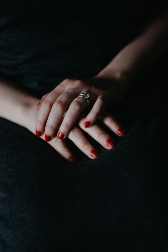 Female hands with red nails and a ring
