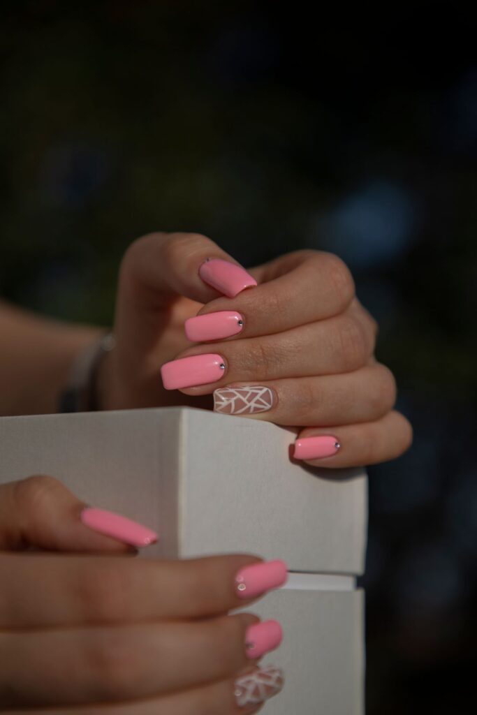 Hand with pink nails holding white box