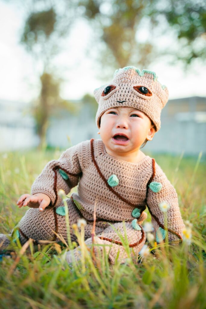 Little baby wearing woolen costume on a meadow
