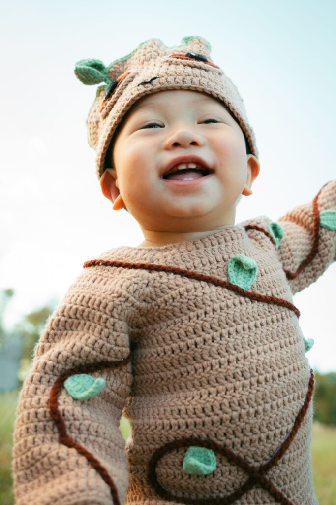 Little baby wearing woolen costume on a meadow