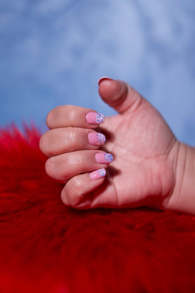 Manicured hand with pink and glitter nail art