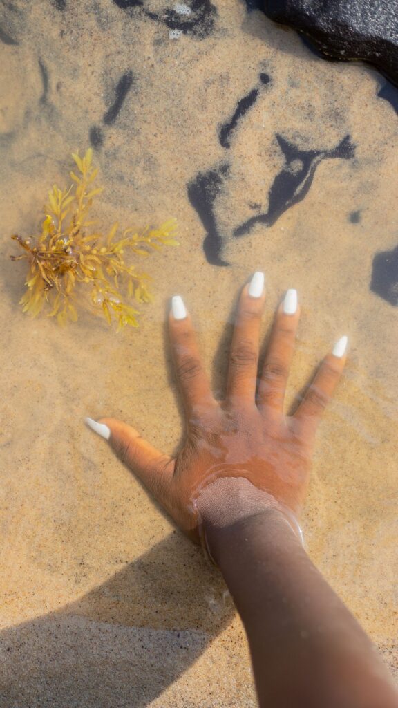 Person's with white nail polish dipped in water