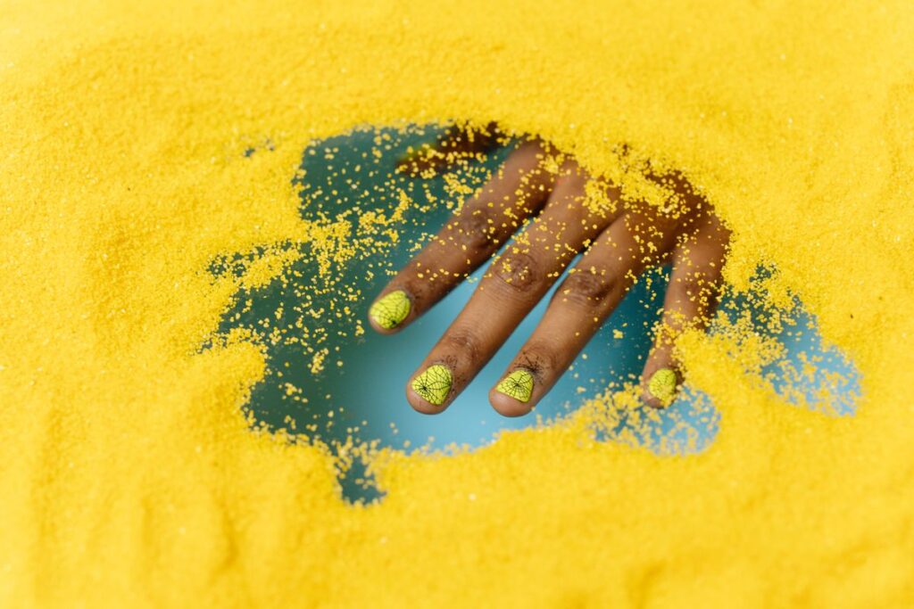 Person with nail art on yellow glitter