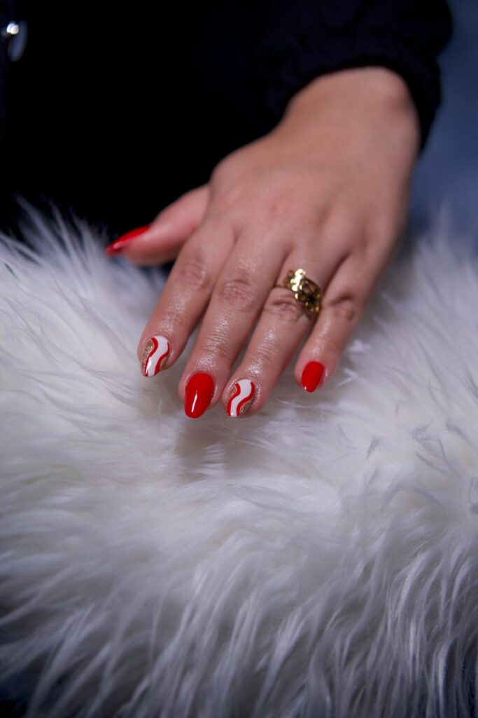 Stylish red manicure on fluffy surface