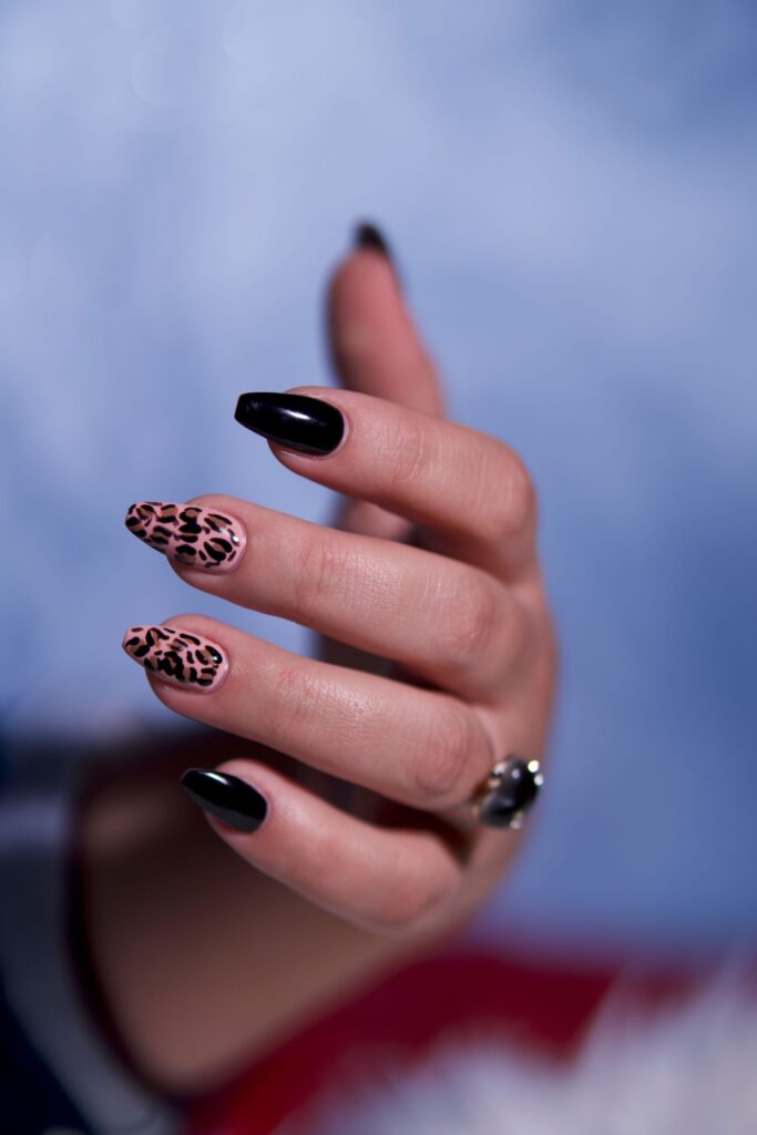 Hand with glossy black and patterned nail art